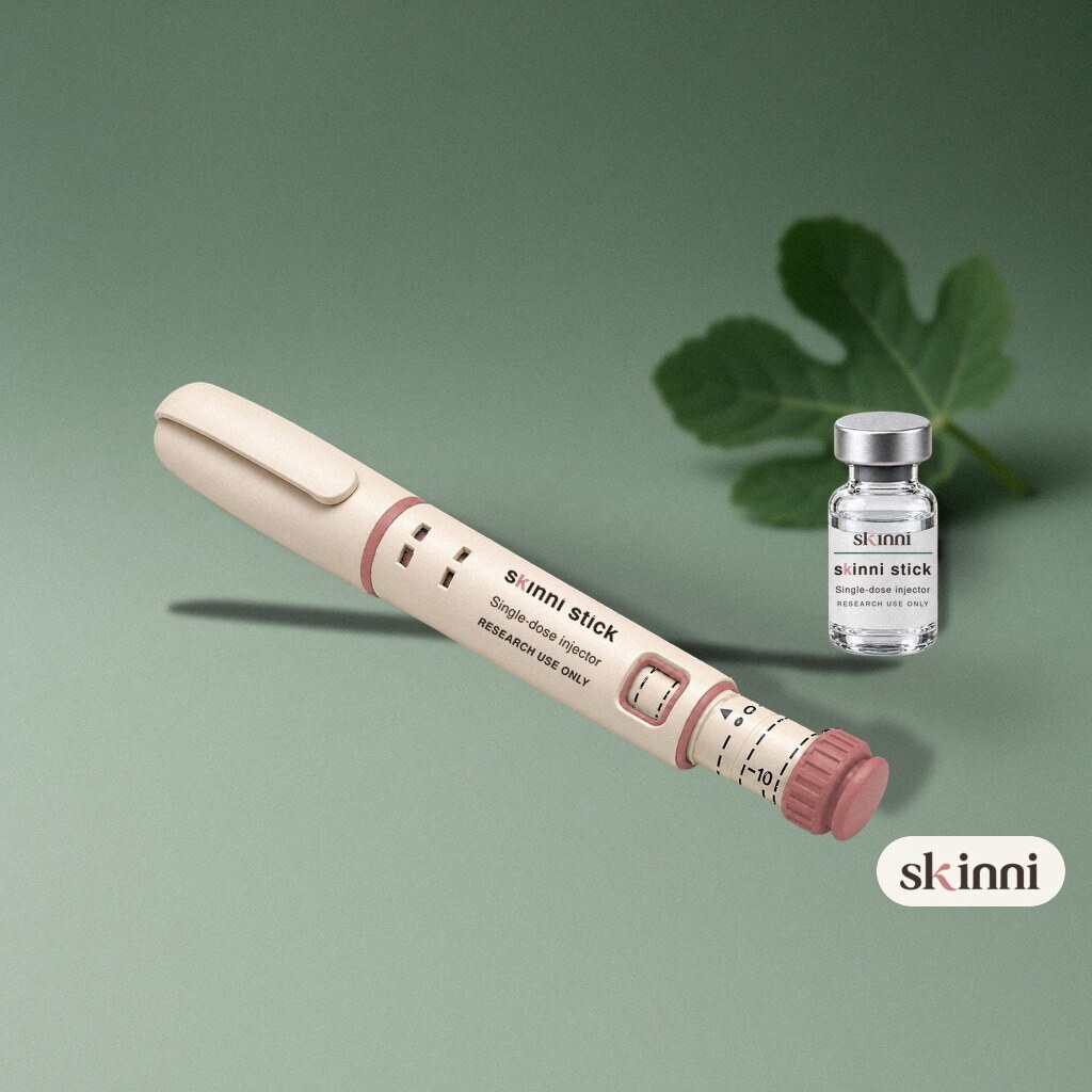 A clear BPC-157 research vial on a coloured plaster ledge, with botanicals beside it