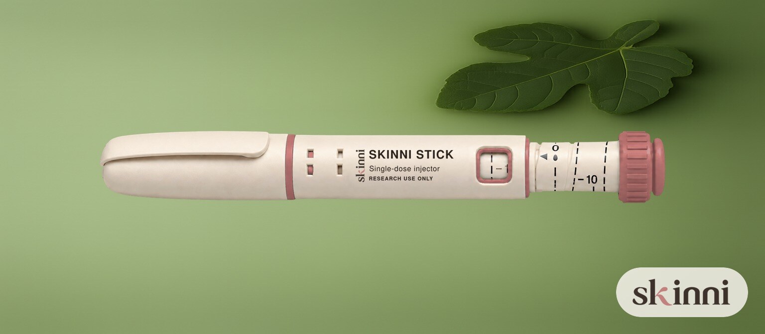 A single Skinni Stick pen on a cream surface
